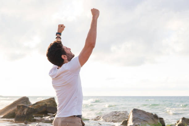 istock Arms raised happy success winning man looking away 1403320216