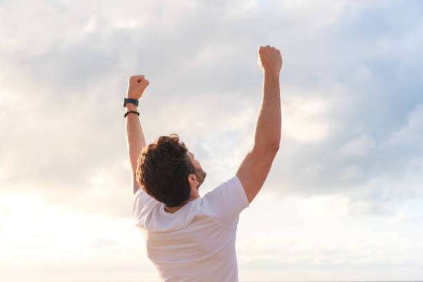 istock Arms raised happy success winning man looking away 1403320224