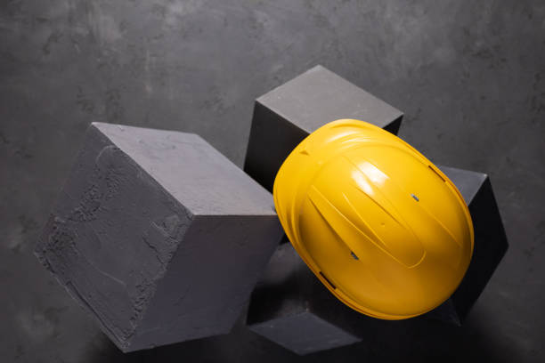istock Concrete cube and construction helmet on floor background texture. Cement block and hardhat 1403320284