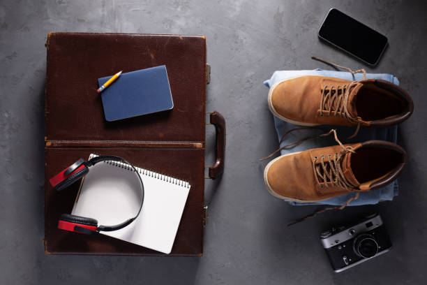 istock Old boots and trip stuff kit on suitcase at floor background. Travel concept idea 1403322483