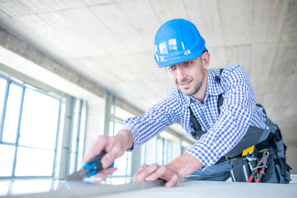 istock A cheerful construction worker cuts drywall with a utility knife. 1403324402