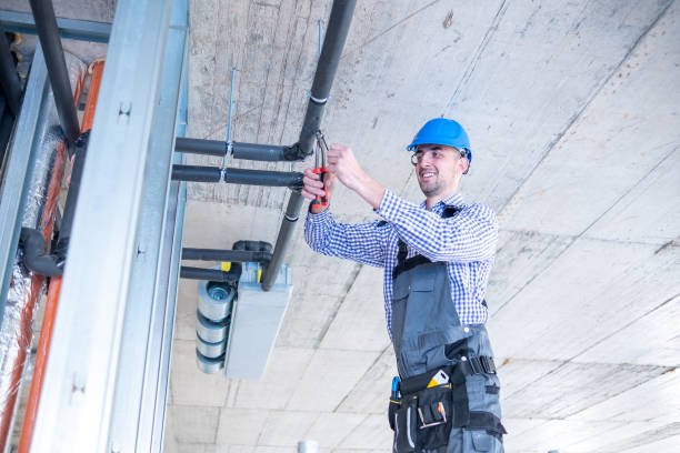 istock Young cheerful construction worker works with pliers over air conditioning unit at construction site. 1403324422