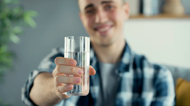istock Young man drinks a glass of water 1403325146