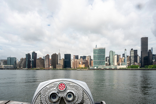 A coin operated viewfinder in Queens overlooks the East River with Manhattan on the other side