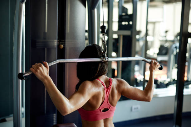 istock A muscular sportswoman is lifting weights on workout machine in a gym. 1403337006