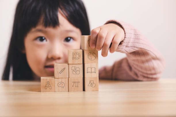 istock Asian kid stack small wooden block to stair. Concept for kid learning and child development. 1403338388
