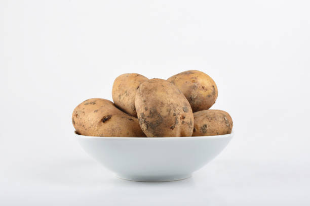 Potatoes in the white bowl on the white background