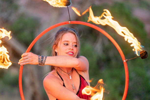 istock Beautiful Young Woman Exotic Fire Dancer Dressed In Red, Twirling And Spinning A Hoop With Fire 1403341122