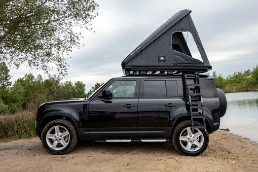 Berlin, Germany - 24th May, 2022: Land Rover Defender with a roof tent. This vehicle is used to get in extremely hard areas.