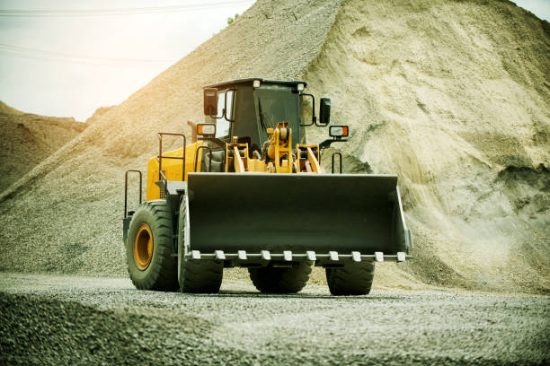 istock Sand loaders are shoveling rocks into dump trucks. 1403350175