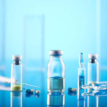 Coronavirus Vaccine: Syringe And Vials On Blue Background