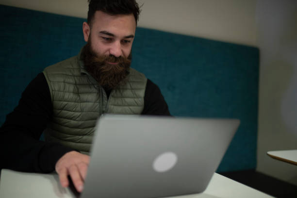 istock A hipster man uses a laptop in his office. 1403351513