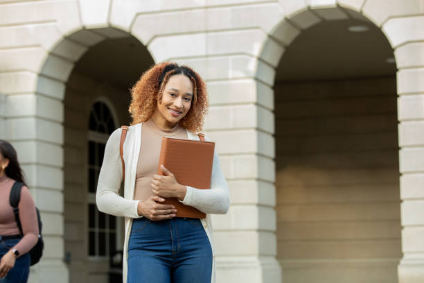 istock Beautiful college student smiles while walking from class on university campus 1403351851