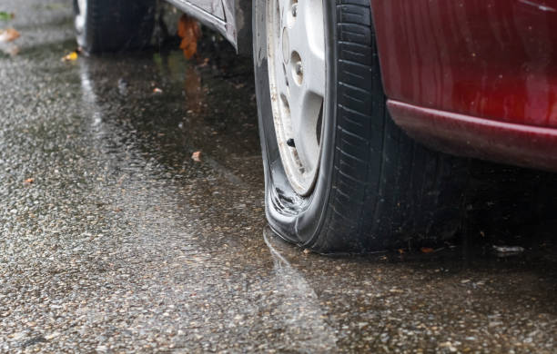 istock Flat tire car in rainy day on street.