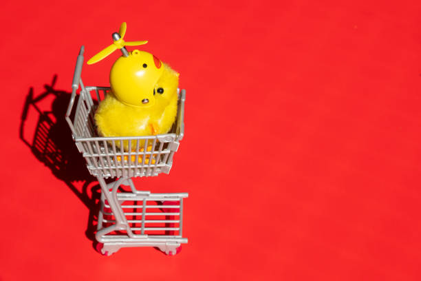 istock Cute little chick inside a shopping cart is alone on a red background. 1403363545