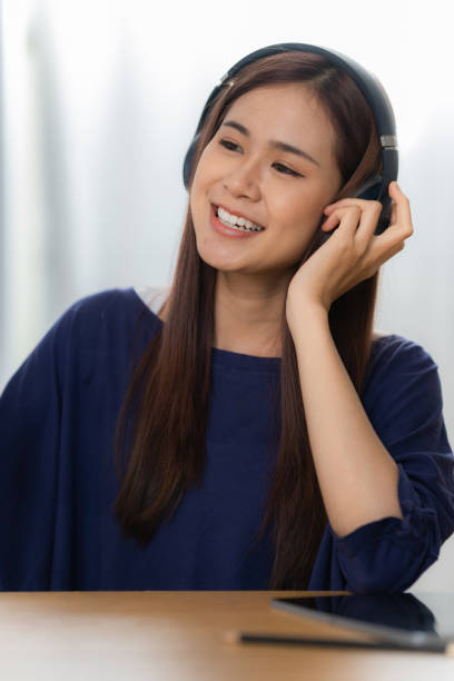 retrato de mulher artista asiática feliz usando telefone inteligente e ouvir música em casa. relaxe o conceito. - hotel domestic room telephone technology - fotografias e filmes do acervo