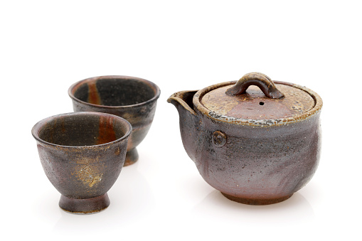 Japanese green tea in a tea set with cup and pot isolated on a white background