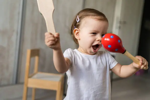 one girl small caucasian child little toddler playing with wooden rattle toy at home copy space