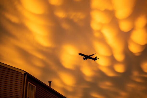 istock Silhouette of Plane Under Mammatus Clouds 1403367512