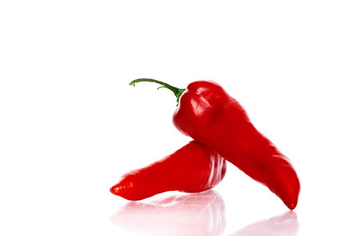 Two red capia peppers isolated on a white background with reflection