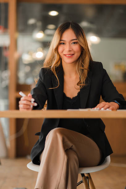 istock Asian female freelancer working using laptop computer in modern office make an account analysis report real estate investment information Business finance and tax system concept, vertical image. 1403374490