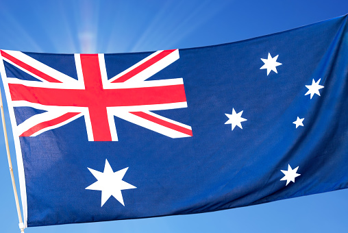 Flag of Australia - blue field with the Union Jack in the upper hoist quarter augmented with a large white seven-pointed star and a representation of the Southern Cross constellation, made up of five white stars