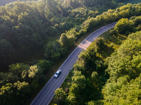 Aerial view on Highway road in the forest. View from a drone. Car in summer time nature from air. Aerial view.