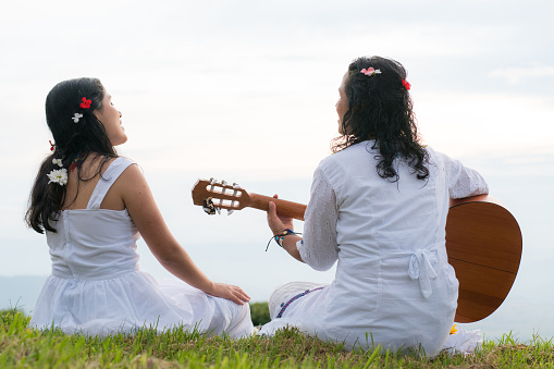 Sensation of free life: Make music outdoors. Indigenous women playing an instrument. release stress with music. Connection with nature. new era of the indigenous population. free lifestyle. indigenous peoples of the world.
