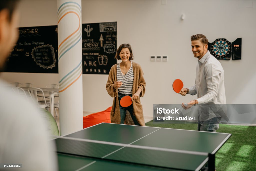 Work and have fun Group of young startup business people playing table tennis together on a boardroom table in an office game room while taking a break from their meeting. Work and fun concept Table Tennis Stock Photo
