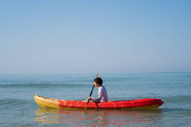 man paddling a kayak boat in the sea