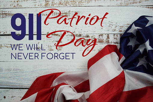 911 Patriot Day We will never forget message with American flag on wooden background