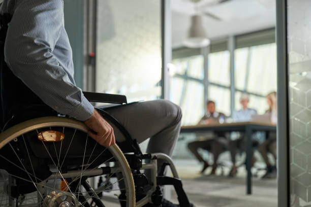 istock Unrecognizable candidate in a wheelchair entering on a job interview. 1403393359