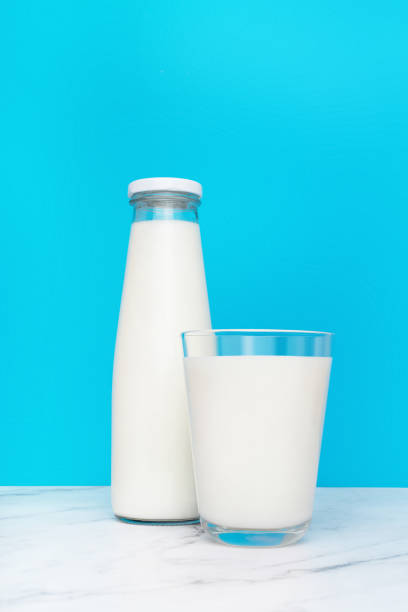 istock bottle and glass with milk on blue background 1403394627