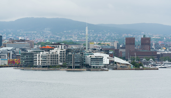Oslo, Norway - June 15th 2022: Oslo city skyline seen from the water on a grey and rainy day. Oslo, the capital of Norway.