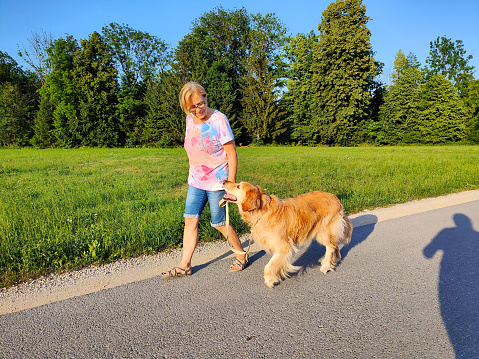 Senior retired woman enjoying a walk with her cute dog
