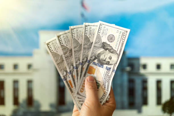 dollars in a man's hand on background Federal Reserve Building in Washington DC, United States, FED dollars in a man's hand on the background Federal Reserve Building in Washington DC, United States, FED wildlife reserve stock pictures, royalty-free photos & images