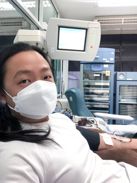 platelet apheresis selfie shot from mobile photo shooting by an asian long hair man in the blood donation room - long hair red hair women men imagens e fotografias de stock