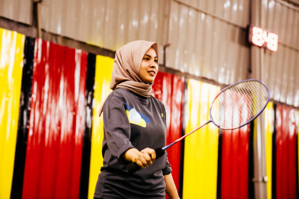 une femme musulmane asiatique frappant un volant avec une raquette de badminton au tribunal. - space shuttle endeavor photos et images de collection