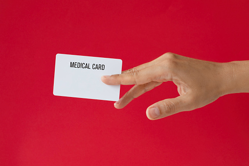 Close-up of a card in a woman's hand isolated on red.