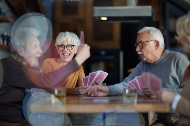 istock Happy mature friends having fun while playing cards at home. 1403404042