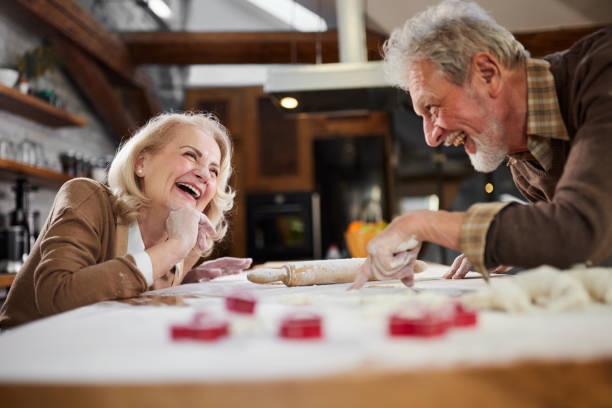 istock Cheerful mature couple having fun while making a cake in the kitchen. 1403406035