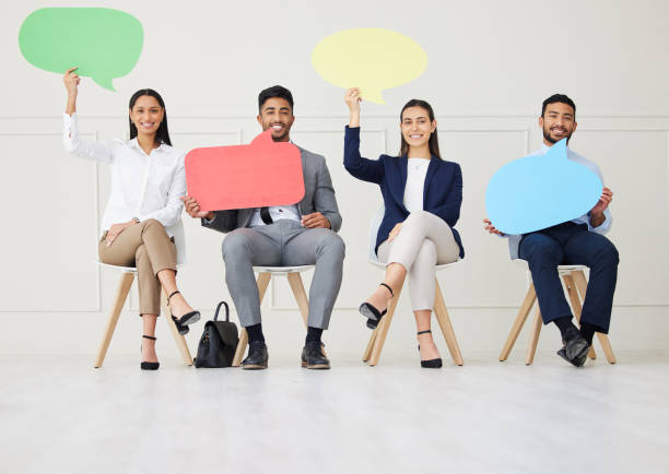 istock Group of diverse businesspeople holding speech bubble while waiting for interview. Team of applicants together. Candidates in line for job opening, vacancy, office opportunity with unique opinions 1403406567