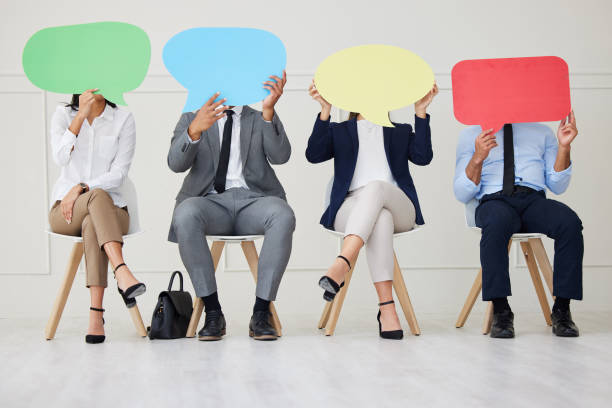 istock Unknown group of diverse businesspeople holding speech bubble while waiting for interview. Team of applicants together. Candidates in line for job opening, vacancy, office opportunity, unique opinions 1403408186