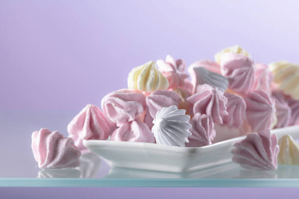 Homemade colorful meringue on a glass table. Copy space.