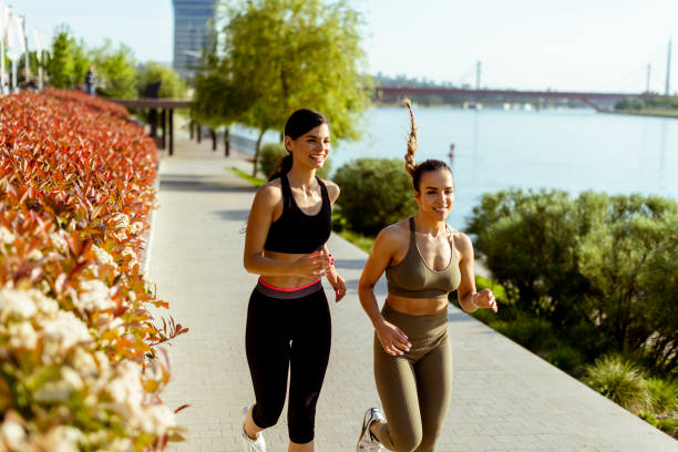 istock Young woman taking running exercise by the river promenade 1403409743