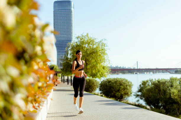 istock Young woman taking running exercise by the river promenade 1403409765