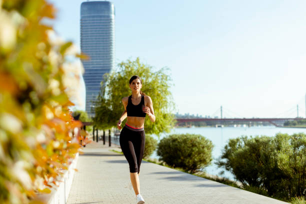 istock Young woman taking running exercise by the river promenade 1403409777