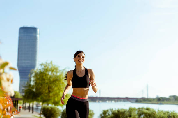 istock Young woman taking running exercise by the river promenade 1403409785