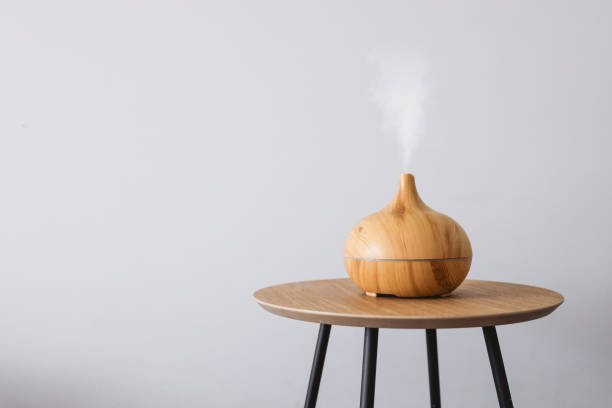 Diffuser of aromatic oil on a wooden table on a white background. stock photo