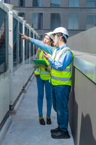 istock Engineer under checking the industry chilled water fan coil unit air conditioner is water cooling tower air chiller HVAC system of large industrial building to control air system 1403411057